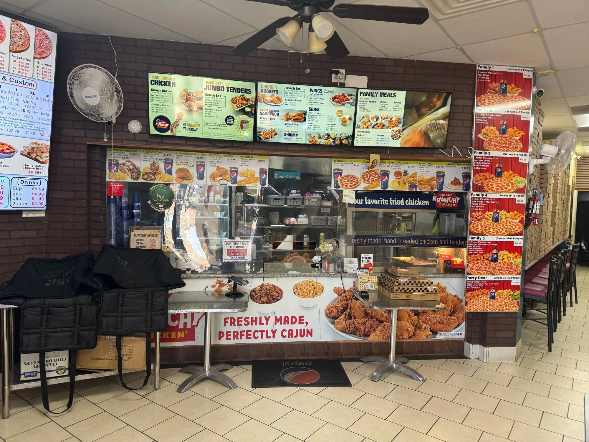 The front counter at Queen Pizza & Krispy Krunchy Chicken in Bakersfield, with menu boards and the chicken counter